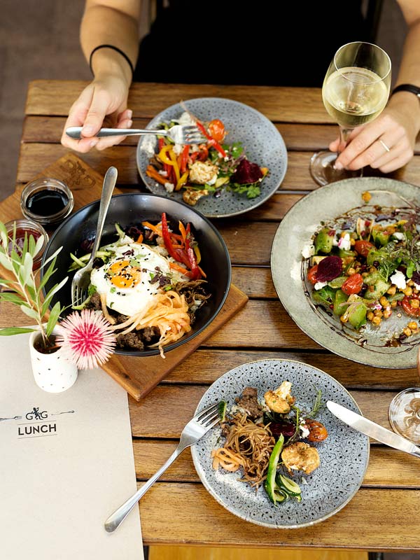 A photo of food on plates on a table with someone eating.