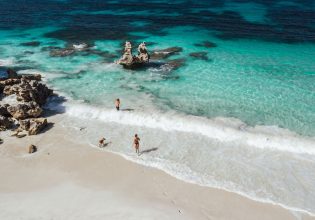 People and dog walking into ocean at Vivonne Bay.