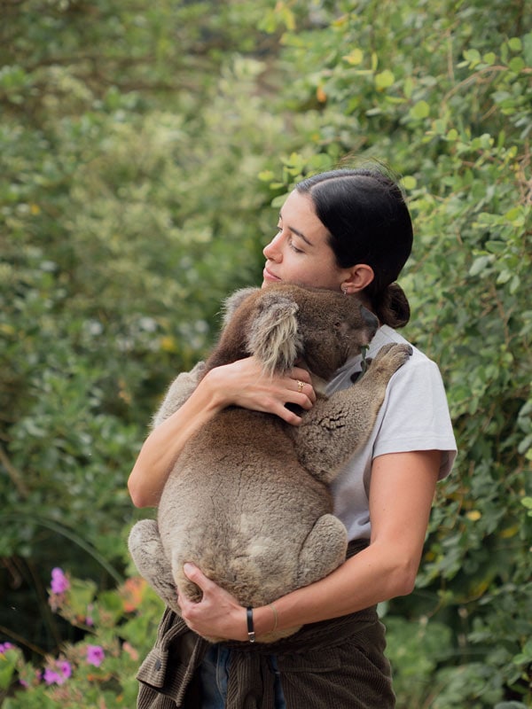 A woman holds a koala in an embrace at Kangaroo Island Wildlife Park.