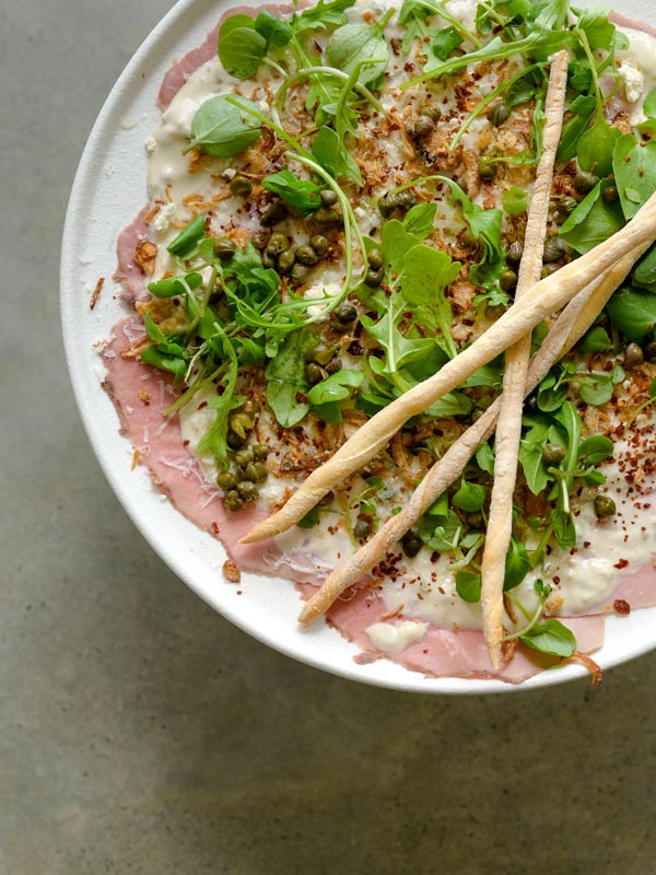 A photo of food in a white bowl on a green table.