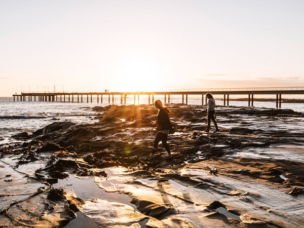 People walking along ocean pools by Lorne Pier