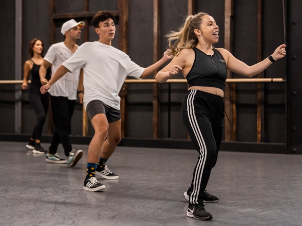 Four people dancing in line.