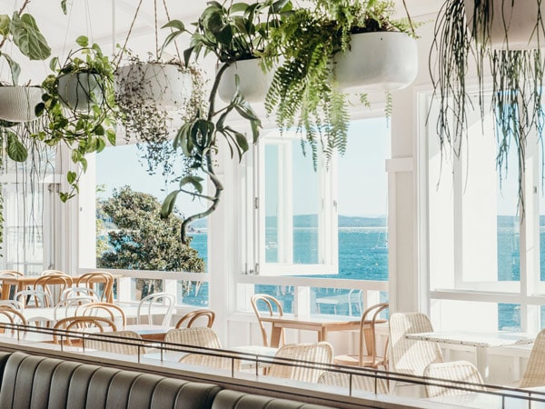 Shoal Bay Country Club overlooking the ocean and the restaurant with hanging plants.