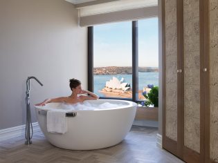 Woman in bath harbour views, Royal Suite, Four Seasons Sydney
