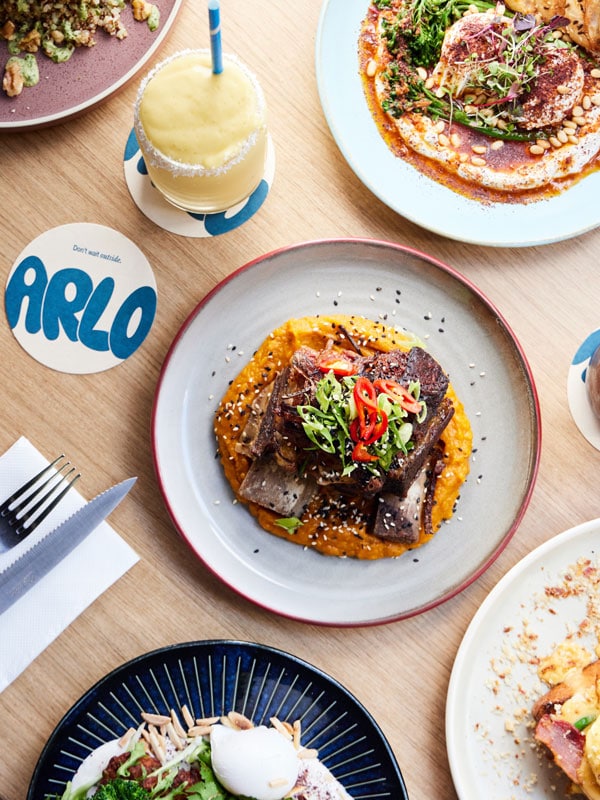 a table-top view of food plates with a drink at Arlo, Elwood