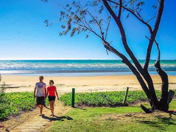 pasangan berjalan-jalan di sepanjang Pantai Balgal, Townsville