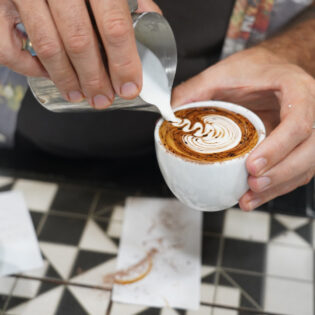 Pouring milk over coffee at Ray’s Patisserie and Cafe, Darwin