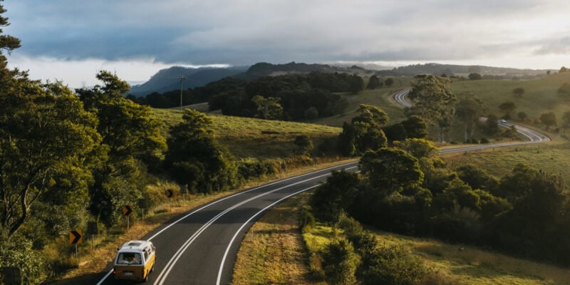 Yellow campervan driving down country roads in Bellingen
