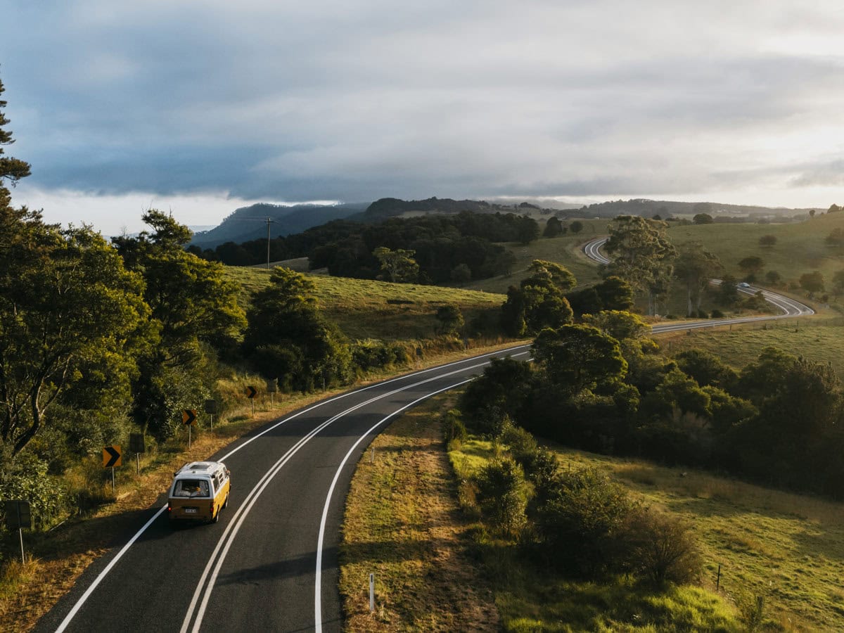 Yellow campervan driving down country roads in Bellingen