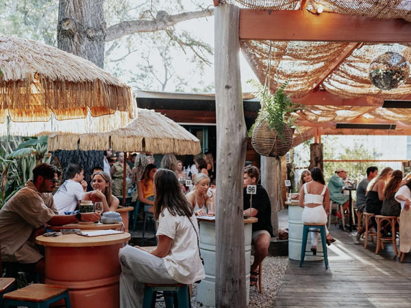 people dining under rustic umbrellas at Bungalow Neighbourhood Social, Margaret River