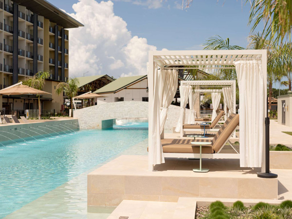 an outdoor pool with daybeds at Mercure Darwin Airport Resort