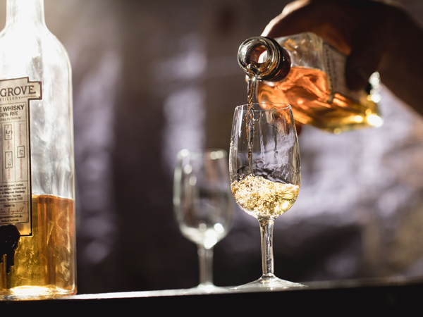 pouring whisky into a glass at Belgrove Distillery, Kempton