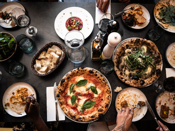 a spread of food and drinks with pizza on the table at Sons of Naples, Margaret River