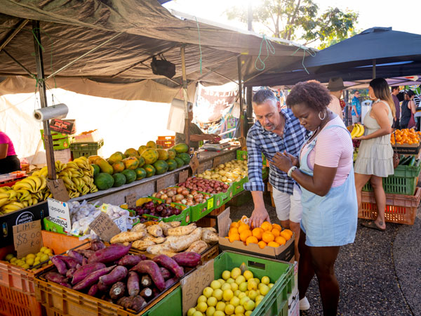 a couple picking fruits at a local produce stall in Parap Village Markets
