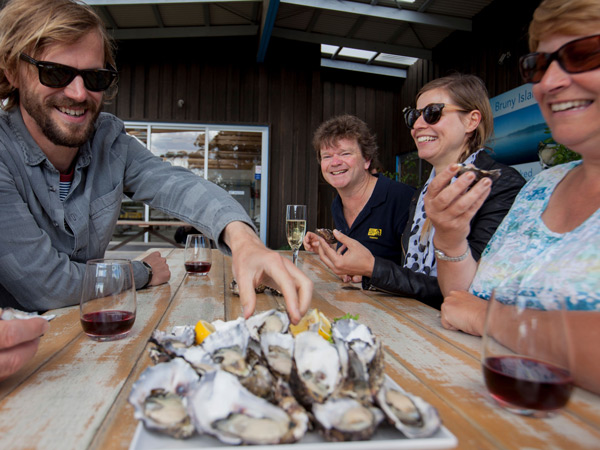 guests enjoying oysters during the Bruny Island Traveller food tour with Pennicott Wilderness Journeys