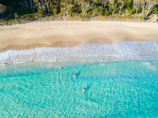 Aerial shot of paddleboarders at Noosa Main Beach - one of the best beaches in Australia