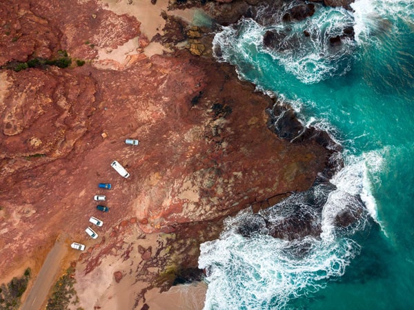 Drone shot of Red Bluff cliffs contrasting with the water.