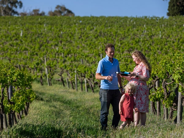 a family standing in the middle of Aphelion vineyard