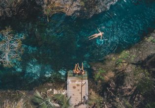 an aerial shot of a girl floating and two girls sitting on the edge of Mataranka Thermal Pool
