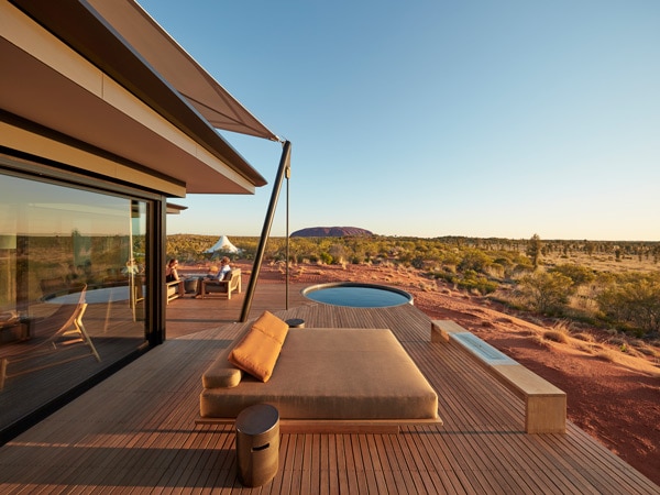 pondok pedalaman dengan kolam kecil dan area tempat duduk yang menampilkan pemandangan Uluru yang indah