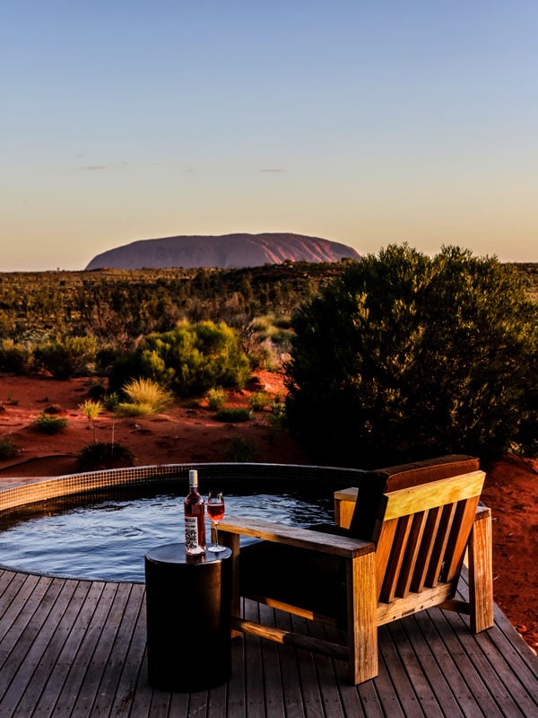 sebotol anggur di atas meja di samping kolam penginapan di Uluru
