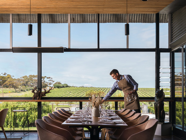 a male staff arranging the dining table at Maxwell, McLaren Vale