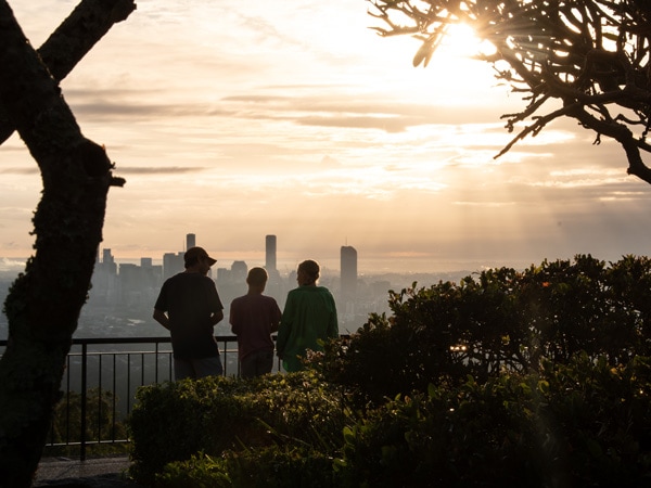 Orang-orang berdiri di Mount Coot-tha Lookout saat mendaki matahari terbenam di Brisbane