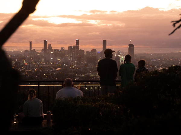 Orang-orang berdiri di Mount Coot-tha Lookout saat mendaki matahari terbenam di Brisbane