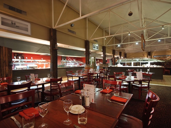 area tempat duduk yang luas di dalam restoran hotel Outback Pioneer Hotel