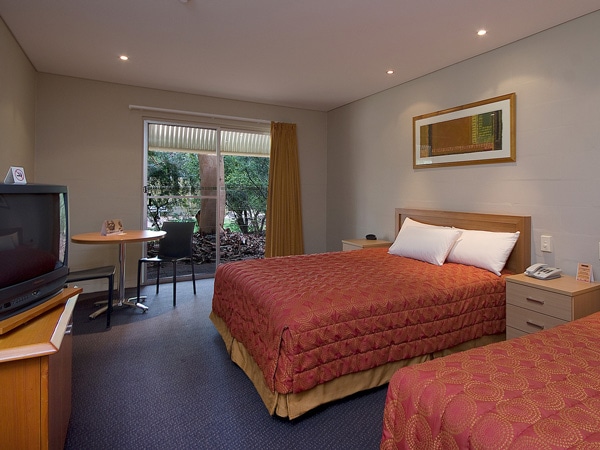 the bedroom inside the standard room at Outback Pioneer Hotel