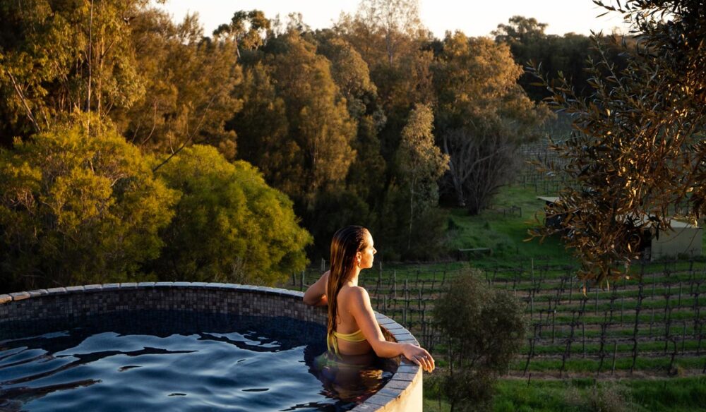 Woman in the pool overlooking vines at Rogasch Cottage in the Barossa Valley