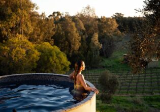 Woman in the pool overlooking vines at Rogasch Cottage in the Barossa Valley