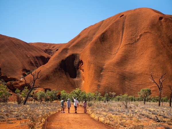 pelancong berjalan di dasar Uluru