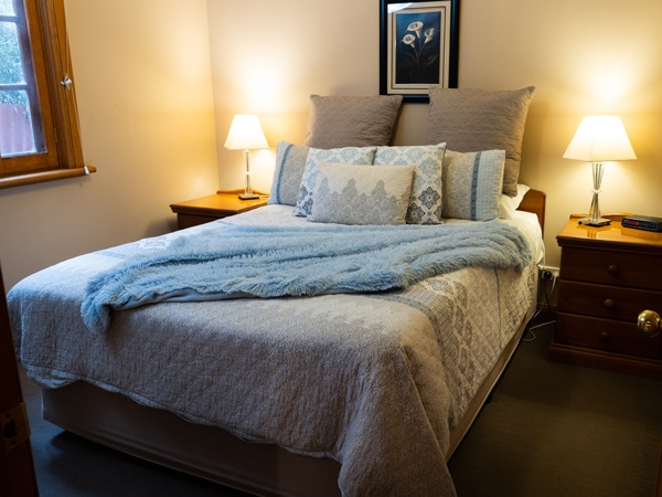 a cosy and well-lit bedroom inside Tanunda Cottages