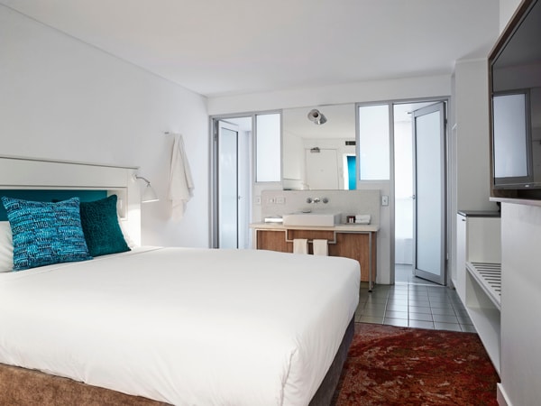 a whitewashed bedroom with a cosy bed at The Lost Camel