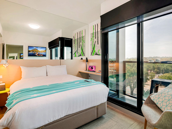 a bedroom with balcony and scenic views at Mercure Bendigo Schaller