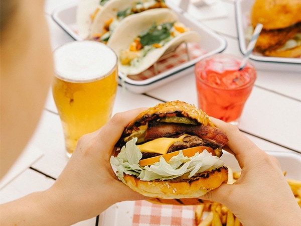 Gambar burger yang akan dimakan bersama koktail dan bir