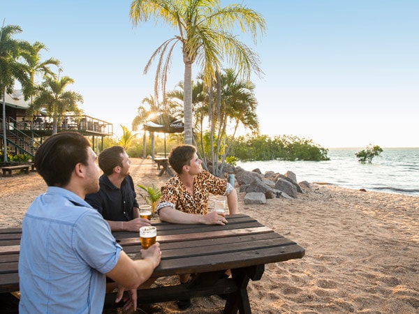 Pria menikmati bir di pub pantai Crab Claw Island Resort 