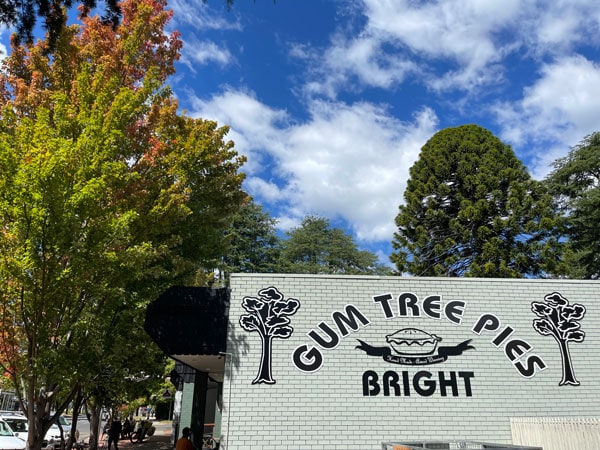 Tanda kafe Gum Tree Pies dikelilingi oleh pepohonan di Bright