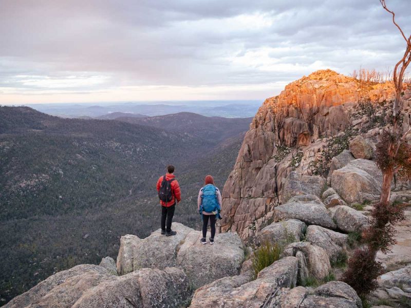 two hikers standing on top of Booroomba Rocks