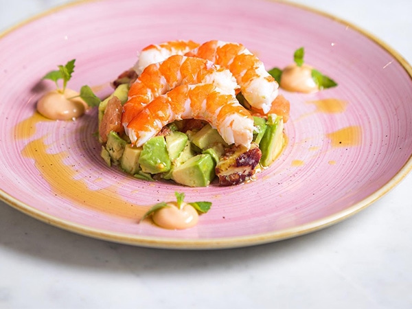 A deconstructed prawn cocktail on a pretty pink plate