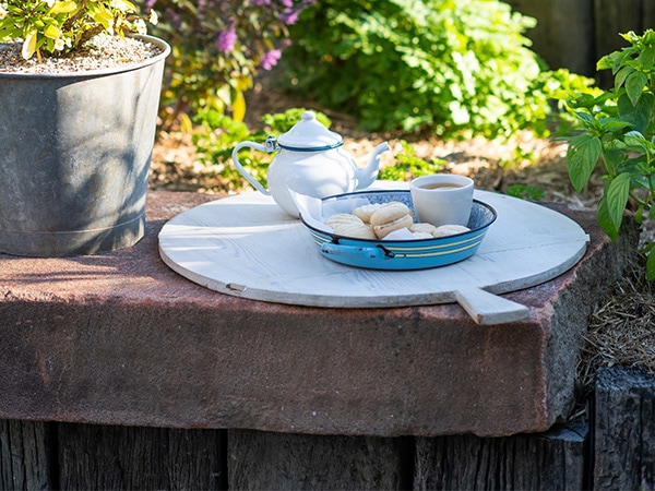 a plate of scones and jams in a rustic garden setting