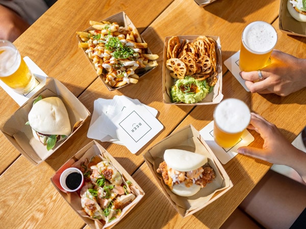 a table top view of tap beers served with burgers and fries at Balter Brewing