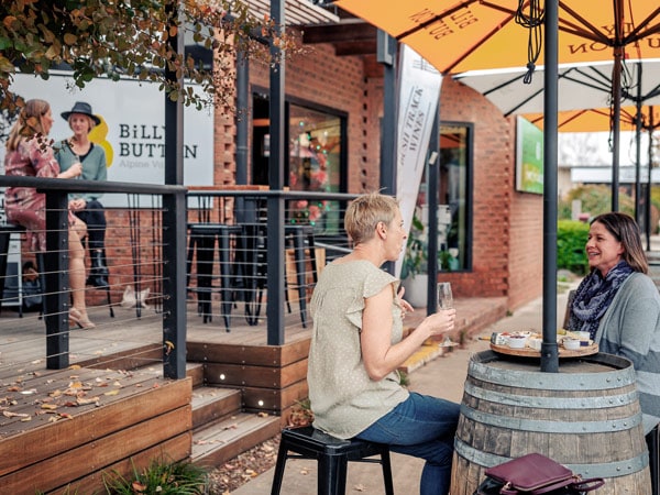 two women talking while drinking wine at Billy Button