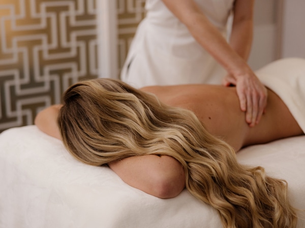 a woman in a lying back position while a therapist gives her a massage at Chuan Spa