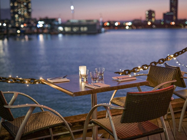 an intimate dinner setup overlooking the sea and city skyline at Glass Dining