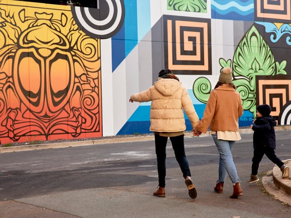 family admiring a graffiti in Braddon
