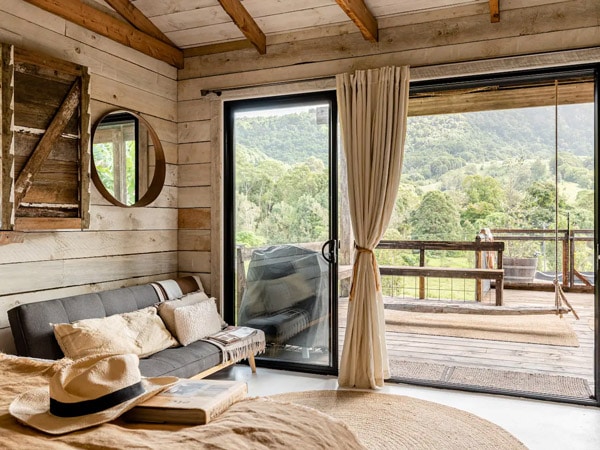 a bedroom with a balcony overlooking nature views at Hillview Dairy, Gold Coast