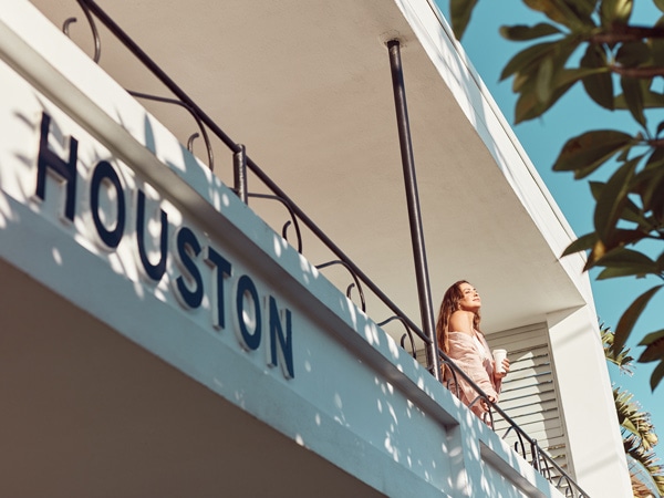 a woman leaning on the railing of a balcony in Houston, Gold Coast