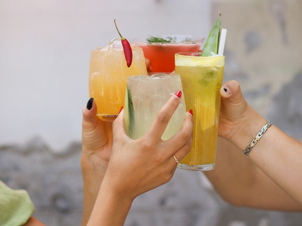 hands holding cocktail glasses at Justin Lane